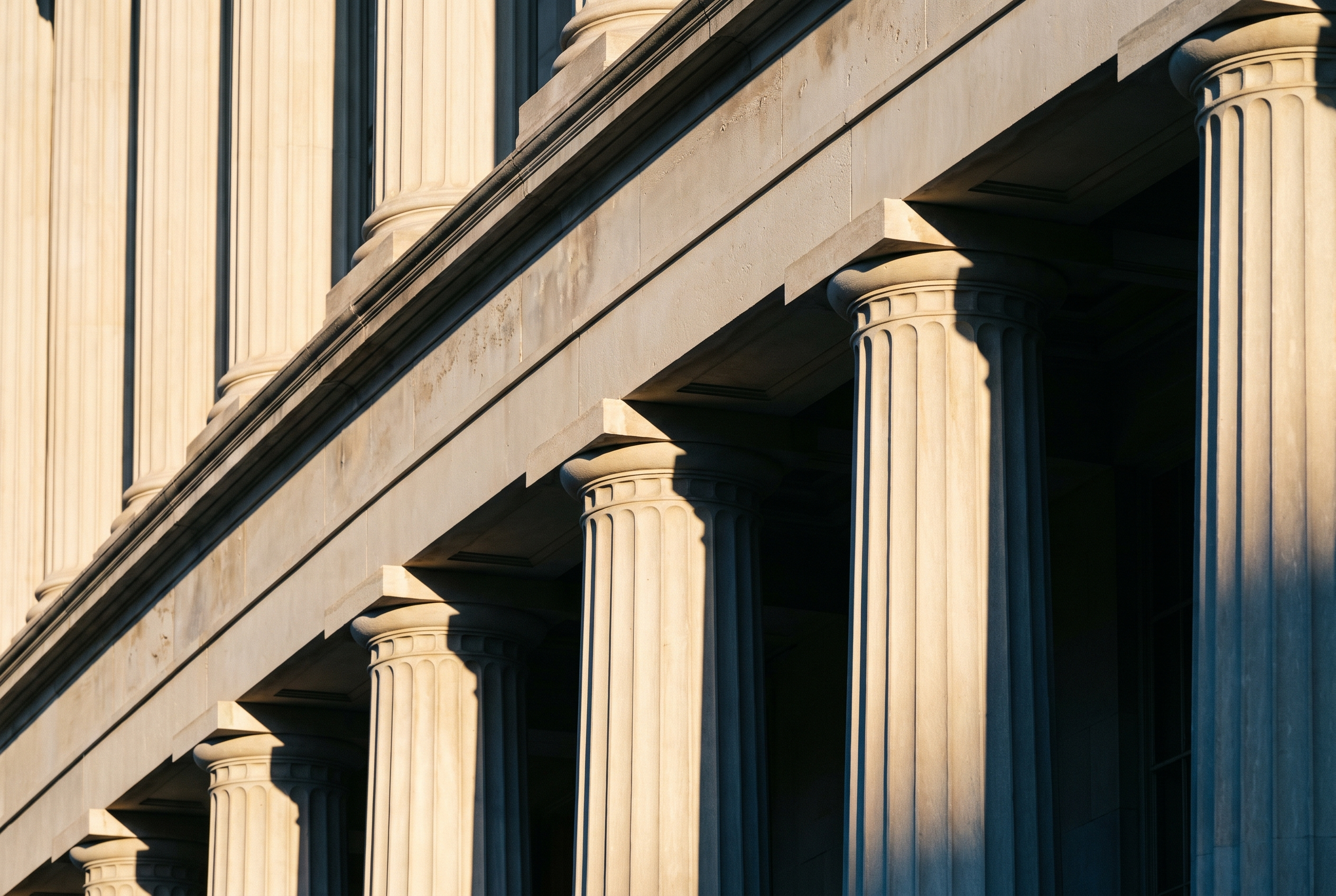 Fluted limestone columns of a Washington, D.C. building in late afternoon light.